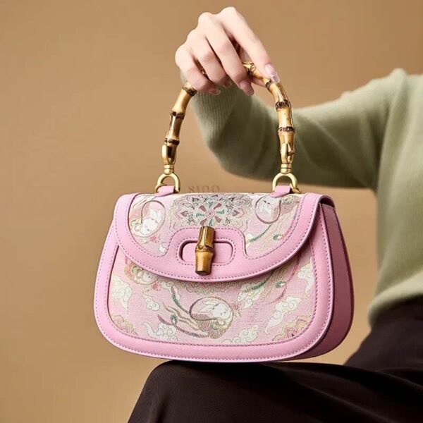 ソン-ブロケード-ピンク-マルベリー-シルク-ハンドバッグ-バンブーハンドル-モデル-シーテッド Song-Brocade-Pink-Mulberry-Silk-Handbag-Bamboo-Handle-Model-Seated